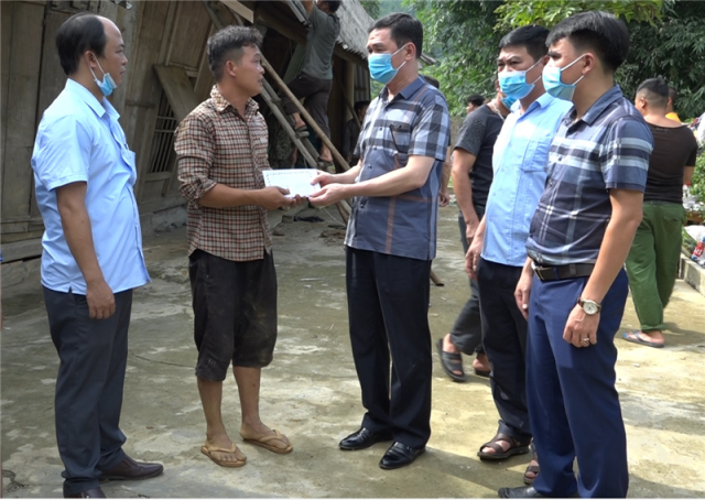 Đồng chí Bí thư Huyện ủy Nguyễn Anh Chuyên trao tiền hỗ trợ cho anh Triệu Hữu Minh bị sập nhà tại bản Bông 3