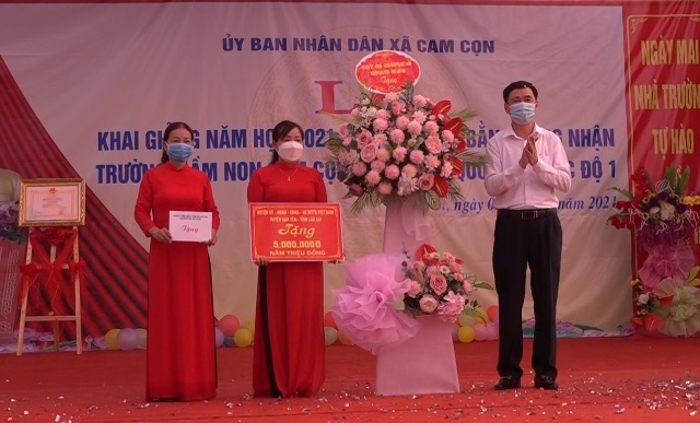 Đồng chí Nguyễn Anh Chuyên, Ủy viên Ban Chấp hành Đảng bộ Tỉnh, Bí thư Huyện ủy, Chủ tịch HĐND huyện tặng hoa và quà chúc mừng hai nhà trường