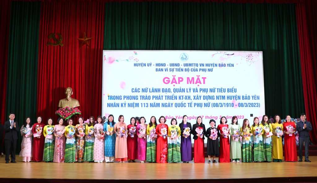 Đồng chí Bí thư Huyện ủy Nguyễn Anh Chuyên và Chủ tịch UBND huyện Trần Trọng Thông tặng hoa và quà chúc mừng các đồng chí cán bộ nữ lãnh đạo, quản lý